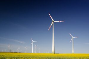 A scenic view of modern windmills spinning against a clear blue sky, symbolizing renewable energy and sustainable practices in action.