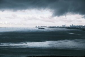 “Satellite image of an intensifying hurricane approaching a coastal city, illustrating rapid storm growth and climate impacts.”