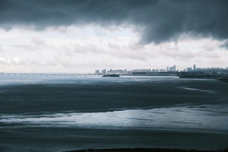 “Satellite image of an intensifying hurricane approaching a coastal city, illustrating rapid storm growth and climate impacts.”