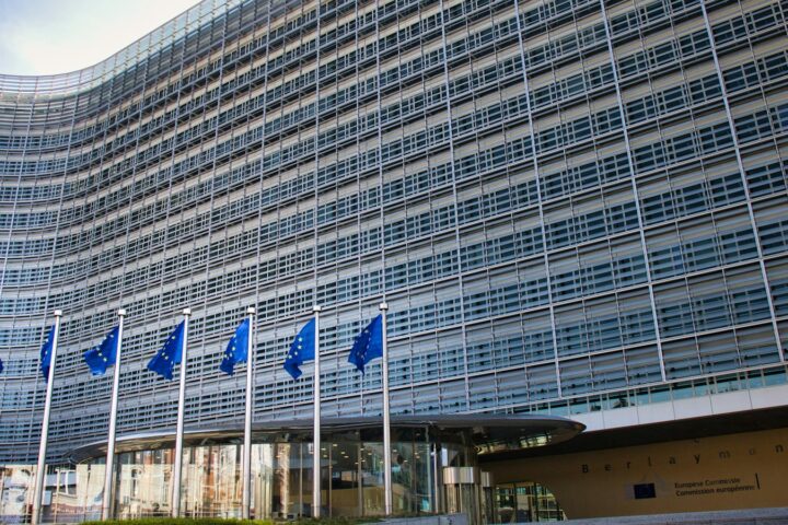 European Commission Berlaymont building in Brussels with EU flags, where the CSRD and ESRS rules are set