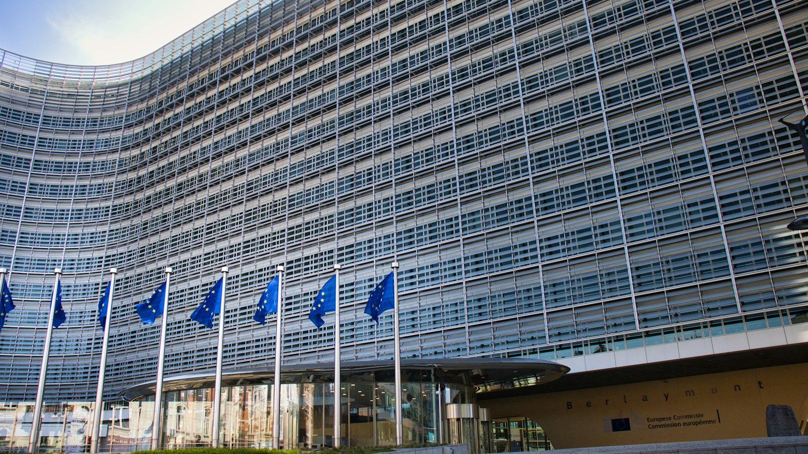 European Commission Berlaymont building in Brussels with EU flags, where the CSRD and ESRS rules are set