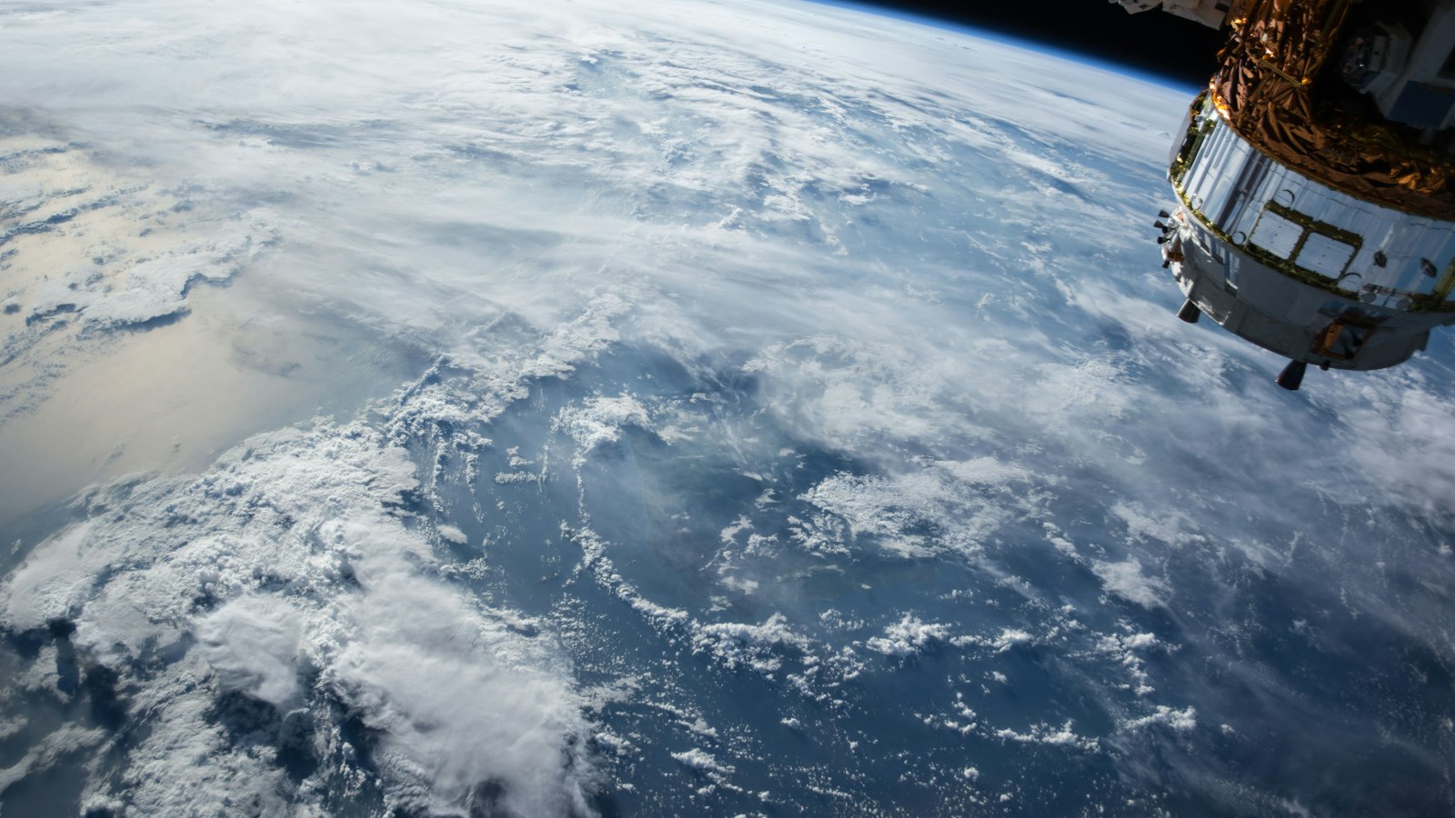 Earth seen from orbit with cloud systems over the ocean, illustrating the ocean-atmosphere coupling behind El Niño
