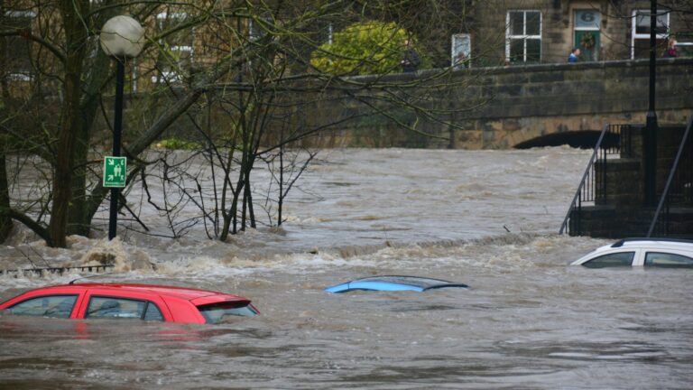 Floodwater submerging cars on a flooded street