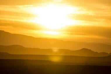 Blazing sun over hazy hills during extreme heat, illustrating the 2026 Lancet Countdown and Super El Niño heat-death forecast
