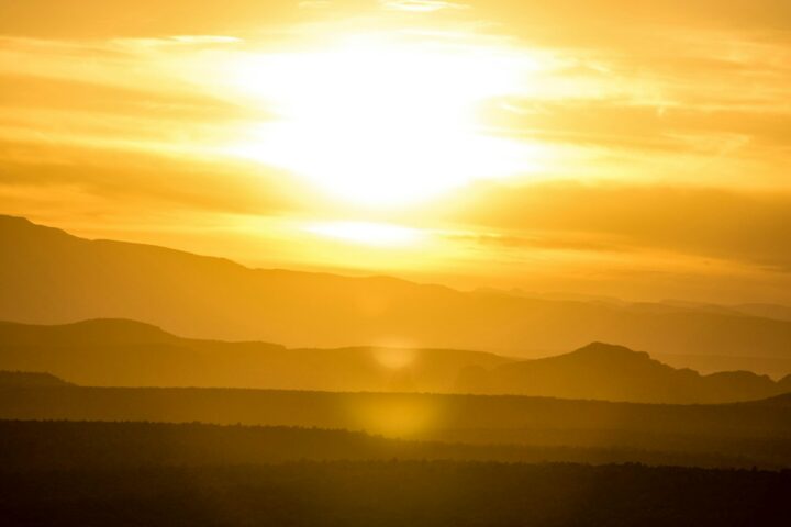 Blazing sun over hazy hills during extreme heat, illustrating the 2026 Lancet Countdown and Super El Niño heat-death forecast