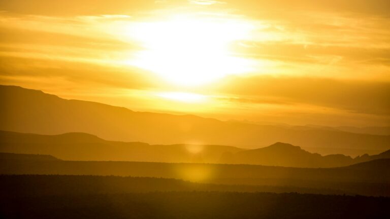 Blazing sun over hazy hills during extreme heat, illustrating the 2026 Lancet Countdown and Super El Niño heat-death forecast