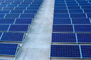 Rows of rooftop solar panels on a flat concrete terrace, the typical PM Surya Ghar residential installation
