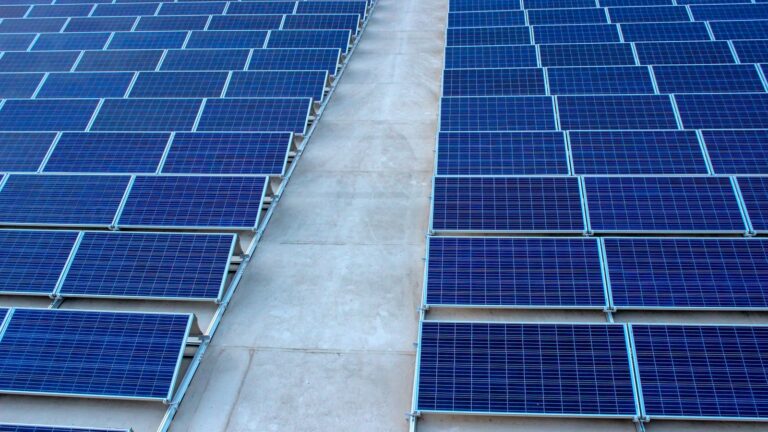 Rows of rooftop solar panels on a flat concrete terrace, the typical PM Surya Ghar residential installation
