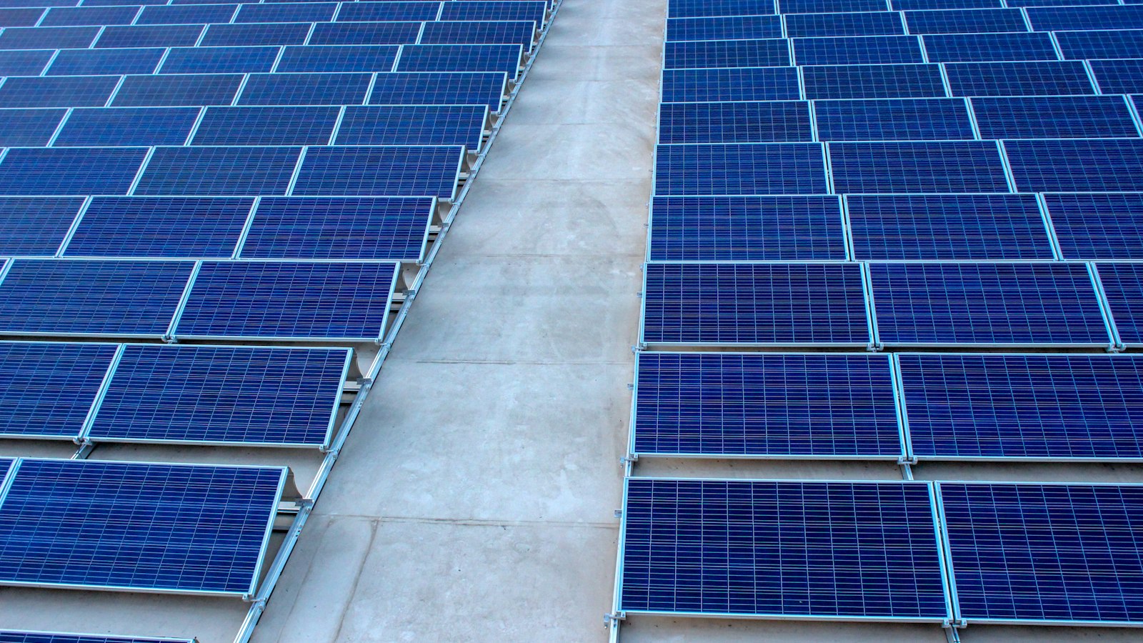 Rows of rooftop solar panels on a flat concrete terrace, the typical PM Surya Ghar residential installation