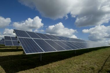 Solar panels under a blue sky with clouds