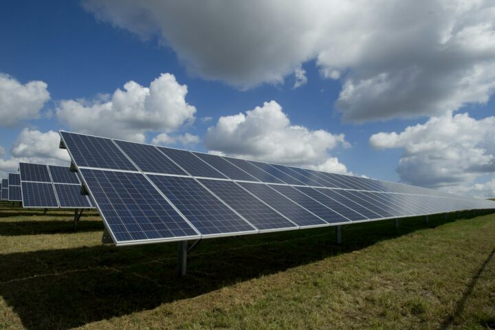 Solar panels under a blue sky with clouds