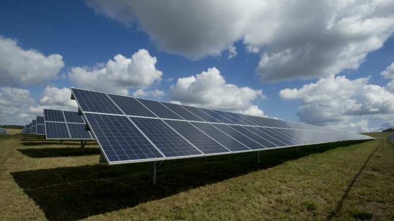 Solar panels under a blue sky with clouds