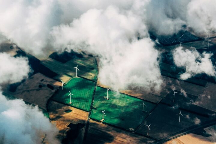 Aerial view of a wind turbine array across farmland, illustrating corporate net-zero decarbonization pathways